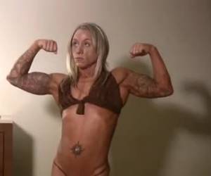 Extreem gespierde powerbabe poseert met haar sexy lichaam in bikini.