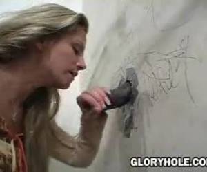 Deze geile blondine pijpt een grote negerlul die door een gloryhole is geduwd. Lekker pijpen tot die grote pik spuitend klaarkomt.